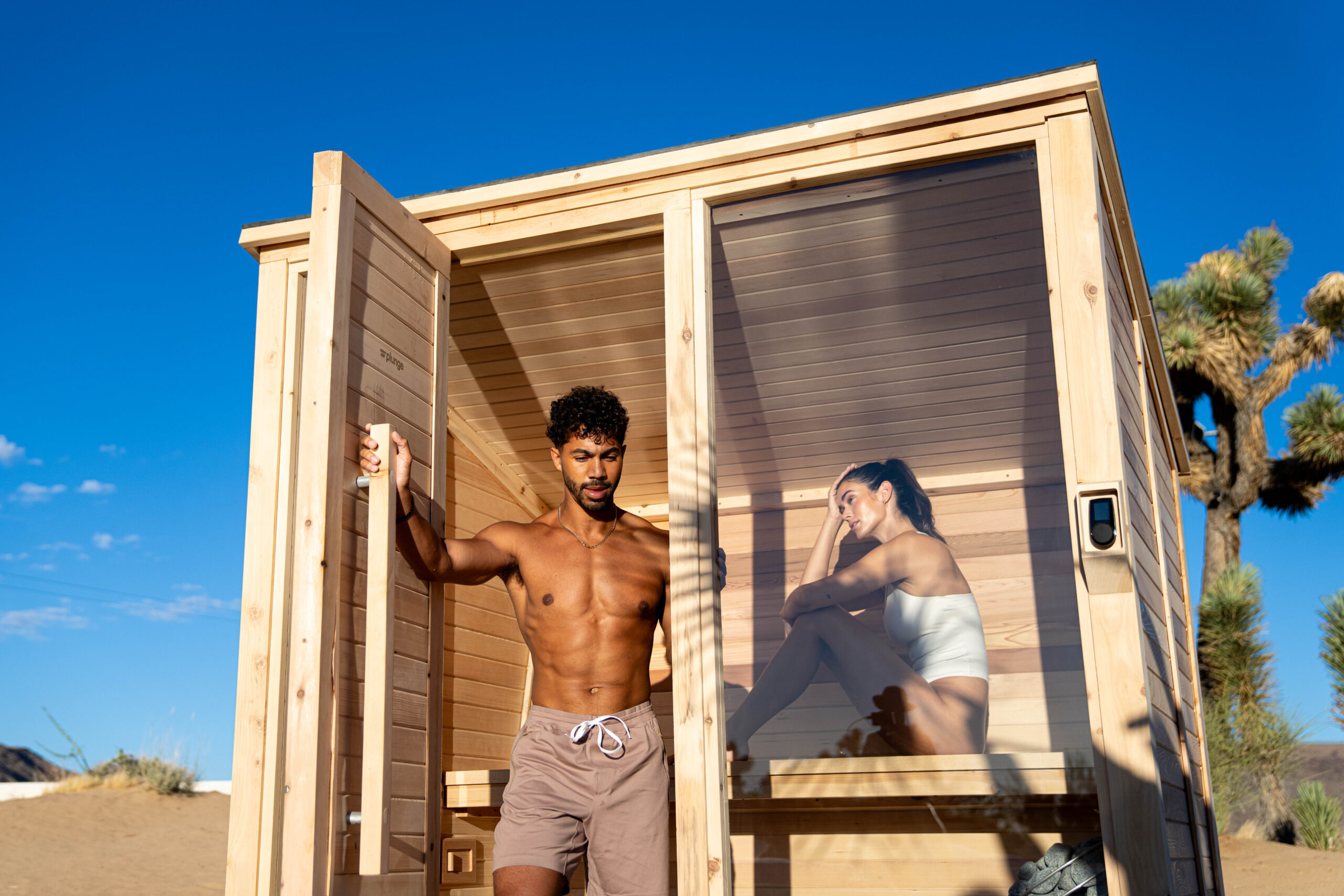 man and woman using sauna in the desert