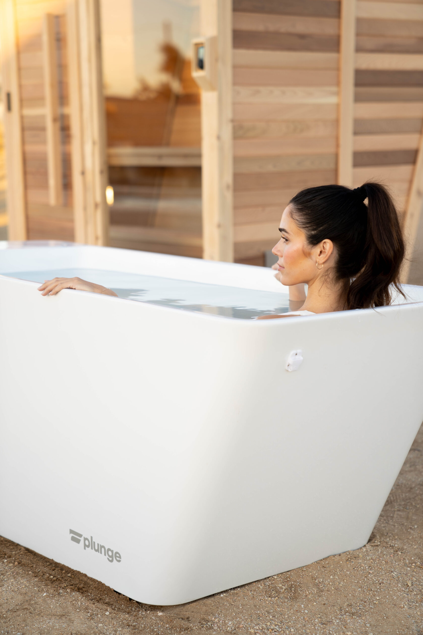 brunette fit woman in tub cold plunge in the desert enjoying her life in san luis obispo county